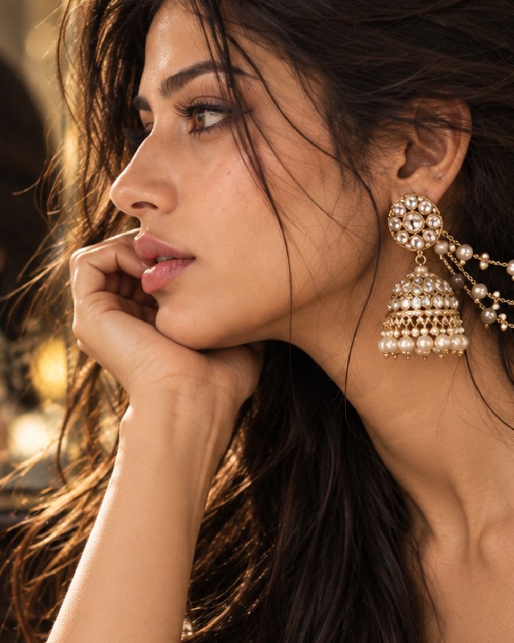 Close crop from the approved Rubans campaign portrait, focusing on the pearl chain and gold-toned earring setting.